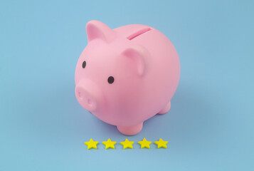 Pink piggy bank with rating stars on blue background. Good way to save money concept.	