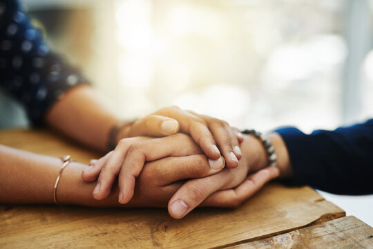 Holding hands, support and comfort of two people talking through a difficult problem. Closeup of friends showing care and love through a hard time, consoling each other and bonding