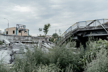 Fototapeta premium IRPIN, UKRAINE - July 18, 2022: War in Ukraine. People cross a destroyed bridge as they evacuate the city of Irpin, northwest of Kyiv, during heavy shelling and bombing