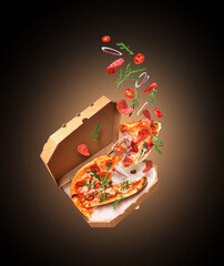 Freshly baked spicy pizza with ingredients in the air on a black background