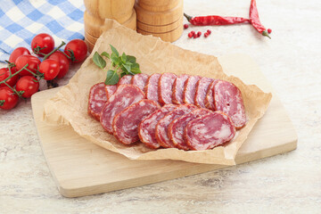 Sliced salami sausages over board