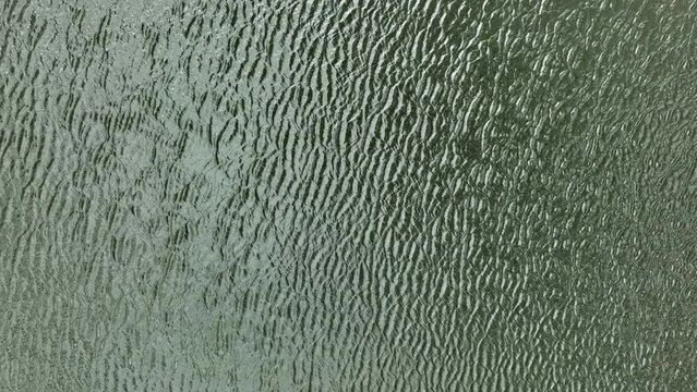 Rippled surface of water in windy conditions; top-down aerial view