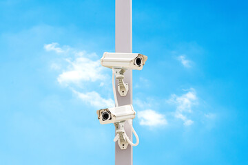 Outdoor white CCTV on pole with blue sky background and copy space