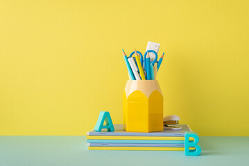 School accessories concept. Photo of stationery on blue desk plastic alphabet letters stack of...
