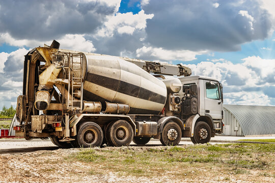 Concrete mixer truck in front of a concrete batching plant, cement factory. Loading concrete mixer truck. Close-up. Delivery of concrete to the construction site. Monolithic concrete works.