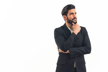 Hispanic businessman with dark slick hair and beard wearing suit looking into the distance with hand on chin thinking and focused. Studio shot. Isolated. High quality photo