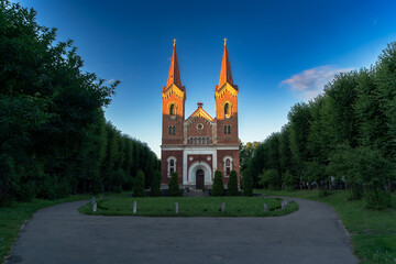 Fototapeta na wymiar Medieval red brick church with two towers in sunset light.