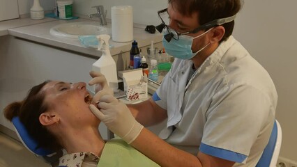 Dental clinic. The doctor prosthetics the teeth of an adult woman.