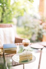 Coconut Cake and Coffee in a cafe on the blur background. traditional dessert Sliced of delicious coconut layer cake