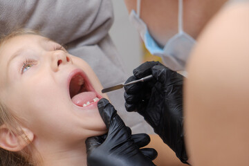 examination, treatment teeth children. Child without milk tooth smiling.medical checkup oral cavity with instruments. dental hands, child in clinic. Happy kid in dentist chair. concept health medicine