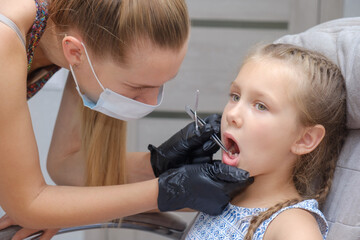 examination, treatment teeth children. Child without milk tooth smiling.medical checkup oral cavity with instruments. dental hands, child in clinic. Happy kid in dentist chair. concept health medicine