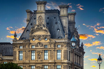 Fototapeta na wymiar Beautiful house in Paris (France) these houses with so many ornaments and monuments are located next to the Seine river in Paris, and creates a nice contrast with a beautiful orange sky.