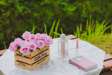 A bouquet of flowers placed next to the book on the table in the morning.