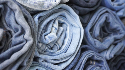 Stack of Various Shades of Rolled Up Denim Jeans Background Banner Texture. 
