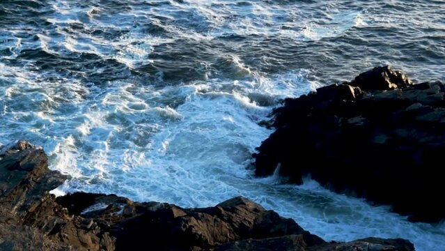 The image shows how coastal rocks are hit by the sea waves.