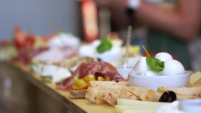 Gastronomy Aperitif Buffet In Restaurant, Hors D'oeuvre, Starters and Assortment of Various Delicious Appetizers Dishes, Mozzarella Cheese Prosciutto and Fresh Food Placed on Wooden Table Counter