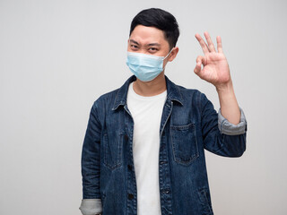 Positive man jeans shirt wear medical mask hand ok sign isolated