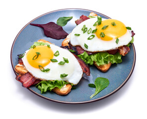 Fried eggs, bacon and cream cheese sandwiches on a plate isolated on white background