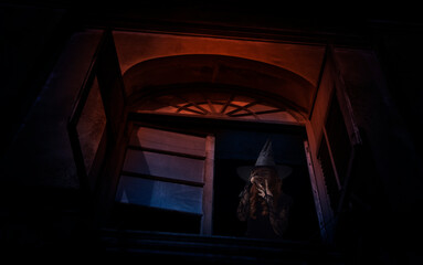 Obraz na płótnie Canvas Scary halloween witch standing in old ancient window castle, Halloween mystery concept