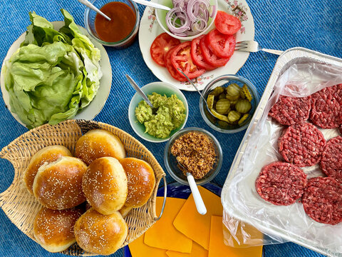 Fastfood, burger party concept. Various delicious burgers set with french fries and sauces on bright blue background flatlay top view copy space
