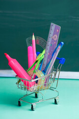 in a cart from a hypermarket there are many different school supplies on the background of a...