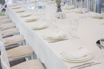 Empty banquet hall ready to receive guests on the summer terrace. white festive table