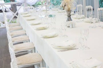 Empty banquet hall ready to receive guests on the summer terrace. white festive table