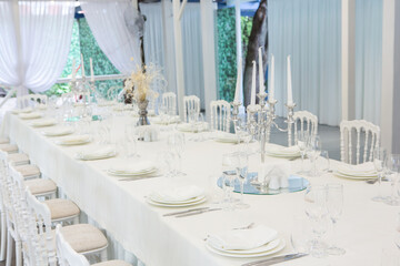 Empty banquet hall ready to receive guests on the summer terrace. white festive table