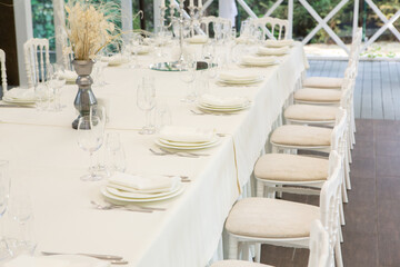 Empty banquet hall ready to receive guests on the summer terrace. white festive table