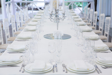 Empty banquet hall ready to receive guests on the summer terrace. white festive table