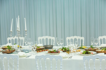 Empty banquet hall ready to receive guests on the summer terrace. white festive table