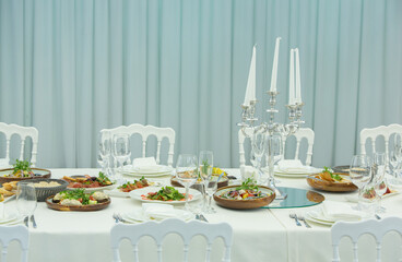 Empty banquet hall ready to receive guests on the summer terrace. white festive table