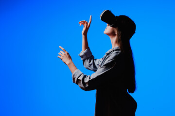 VR virtual reality glasses on a girl. Looks to the future. Touching the new. Fantastic virtual...