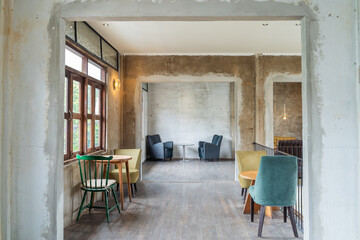 The wooden tables and chairs in old house with sunlight through the windows