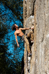 Sports man is engaged in rock climbing