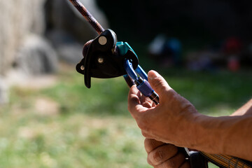 A man closes a rock climbing carabiner close up