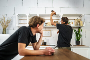 Obraz premium Two guys have fun in the kitchen using a digital tablet online