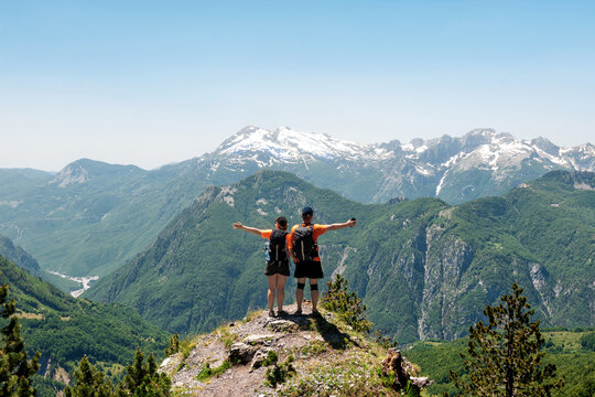 A couple of tourists rest on a meadow in the mountains of Albania. Mountains on the north Albania