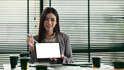 Gorgers female entrepreneur holding and showing digital tablet. Empty screen for your advertise text