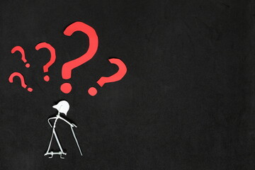 Senior or old people dementia problem, memory loss and Alzheimer's disease concept.  Elderly woman stick figure with red question mark in dark black background creative composition.