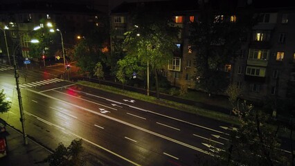 Timelapse view on a road with fast moving cars at the night after rain