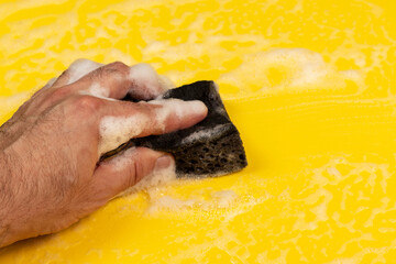 Hand with foam washing sponge .