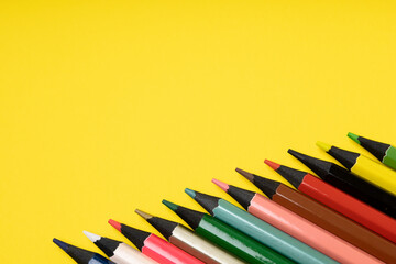 colored pencils on a yellow background