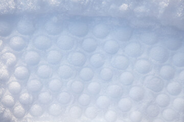  A trace of convex circles in the snow, a circle tread print on a white background. Imprint pattern...