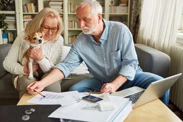 Senioren Paar mit Hund macht zusammen Buchhaltung - obrazy, fototapety, plakaty