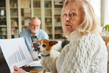 Seniorin mit Taschenrechner und Diagramm macht sich Sorgen