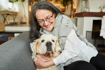 Glückliche Seniorin im Ruhestand kuschelt mit Hund