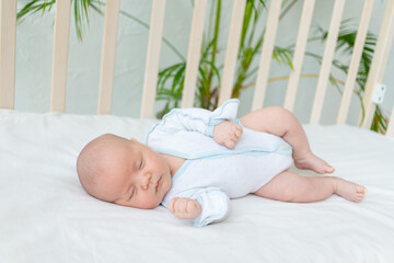 newborn baby boy sleeps seven days in a cot at home on a cotton bed, healthy baby sleep