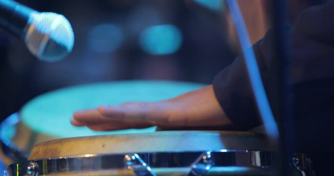 Footage of a musician hitting the wood bongo drums