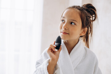 Preteen girl washing her face with sponge